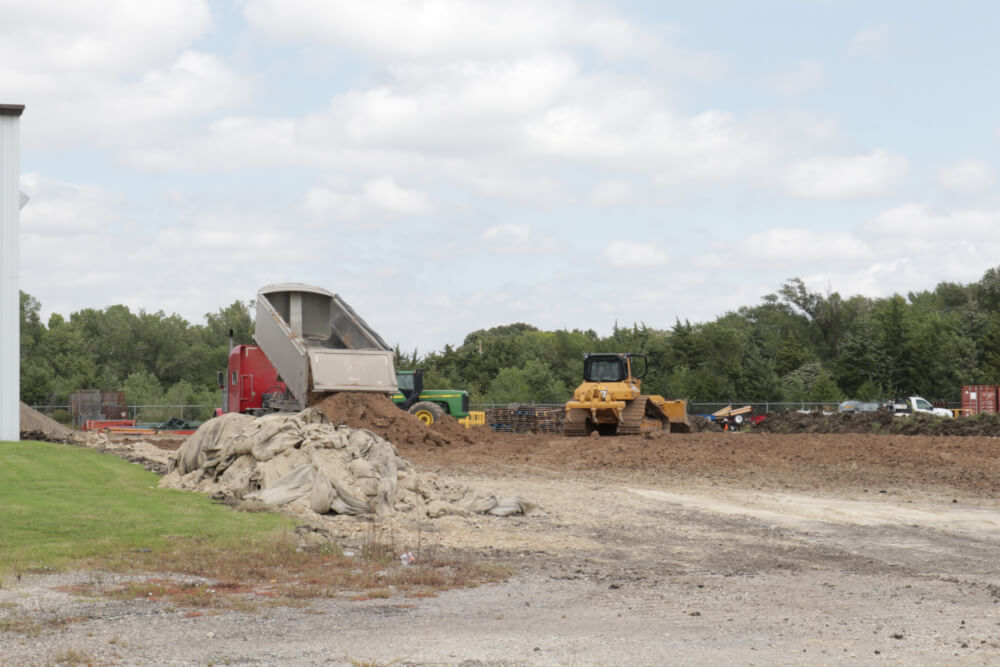 Adding dirt to level the ground for foundation work. 