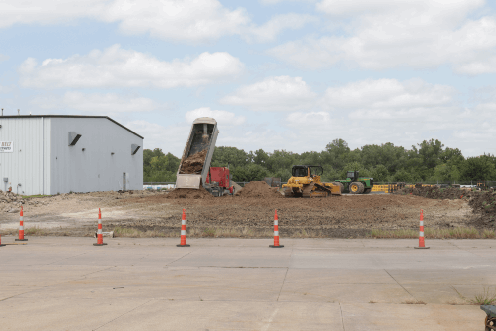 Adding dirt to level the ground for foundation work. 